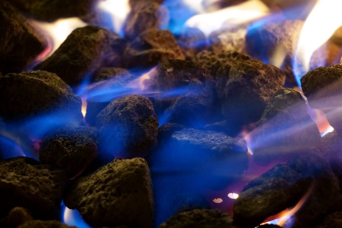 Blue and orange flames rising over coals